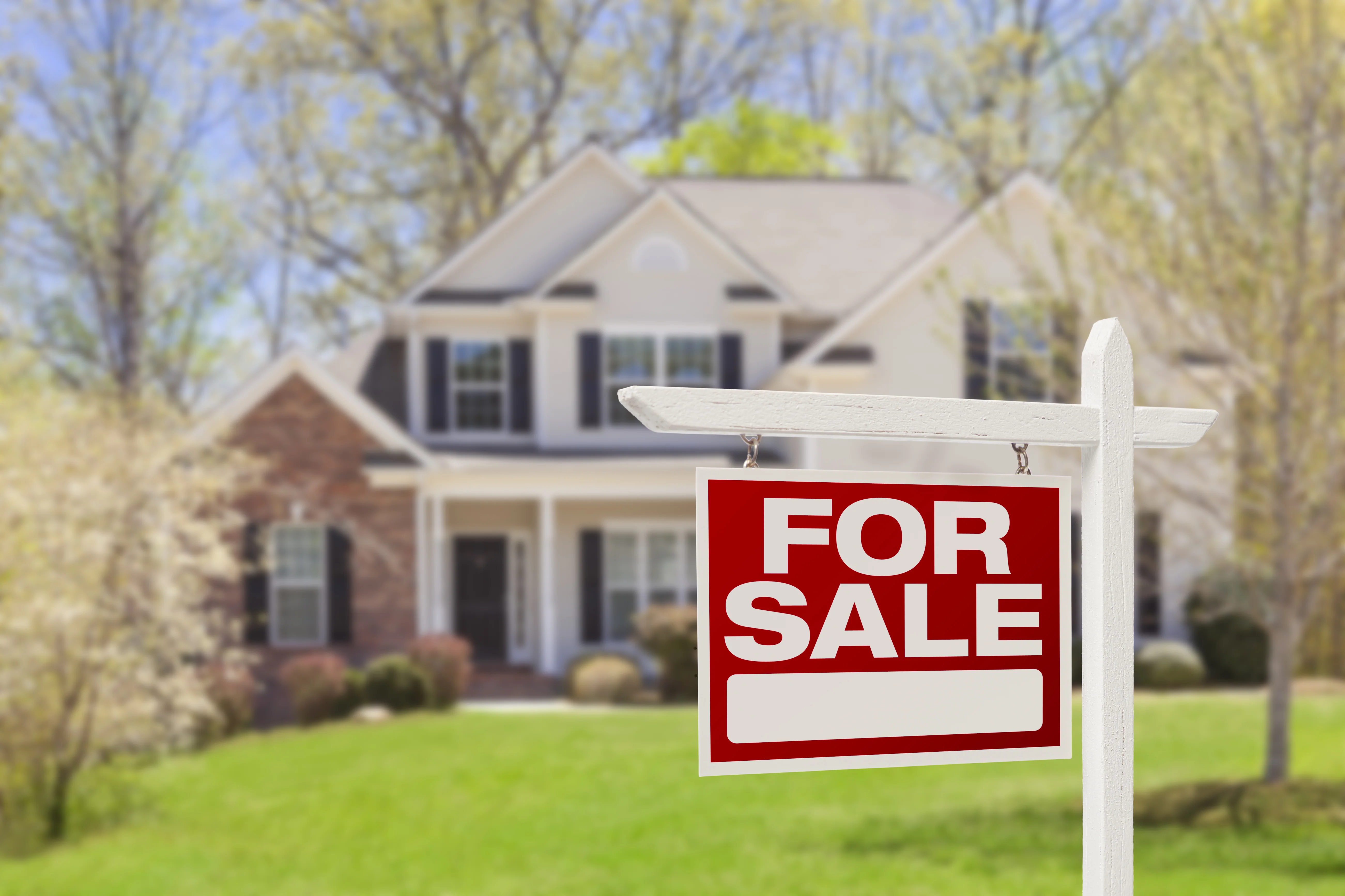 House with for sale sign.